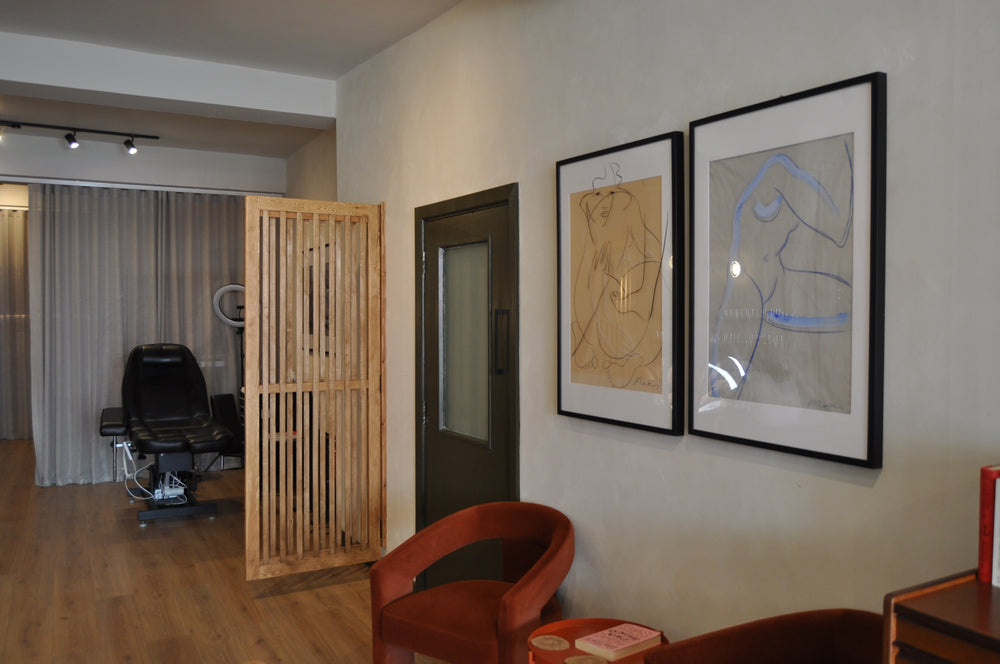 Rust-coloured seating, framed drawings and the open studio floor at SHY