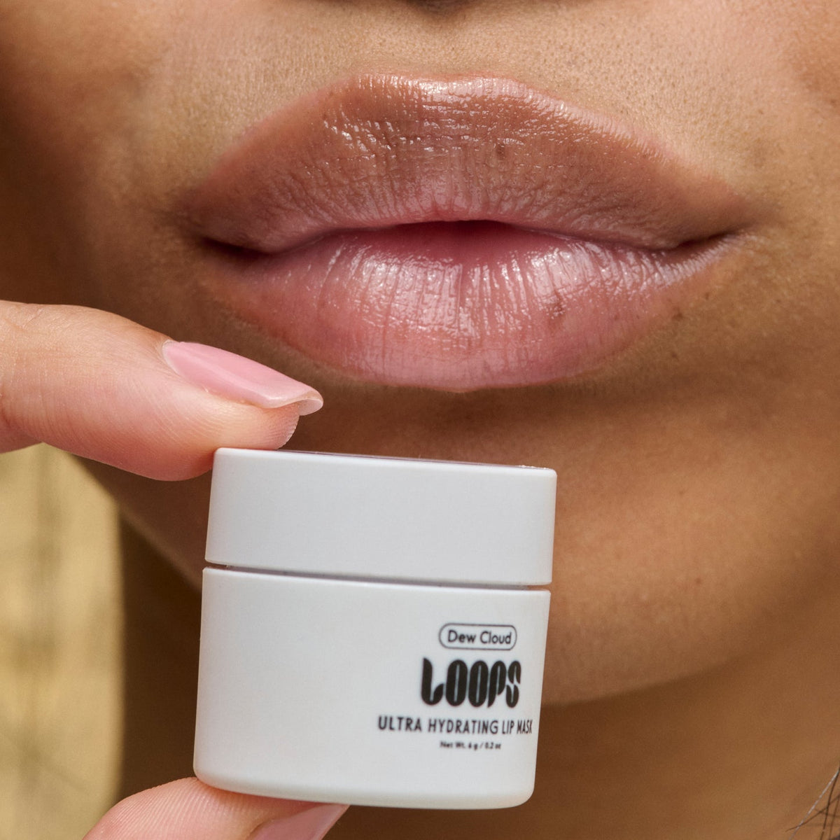 LOOPS Dew Cloud Mini Lip Mask held beside moisturised lips